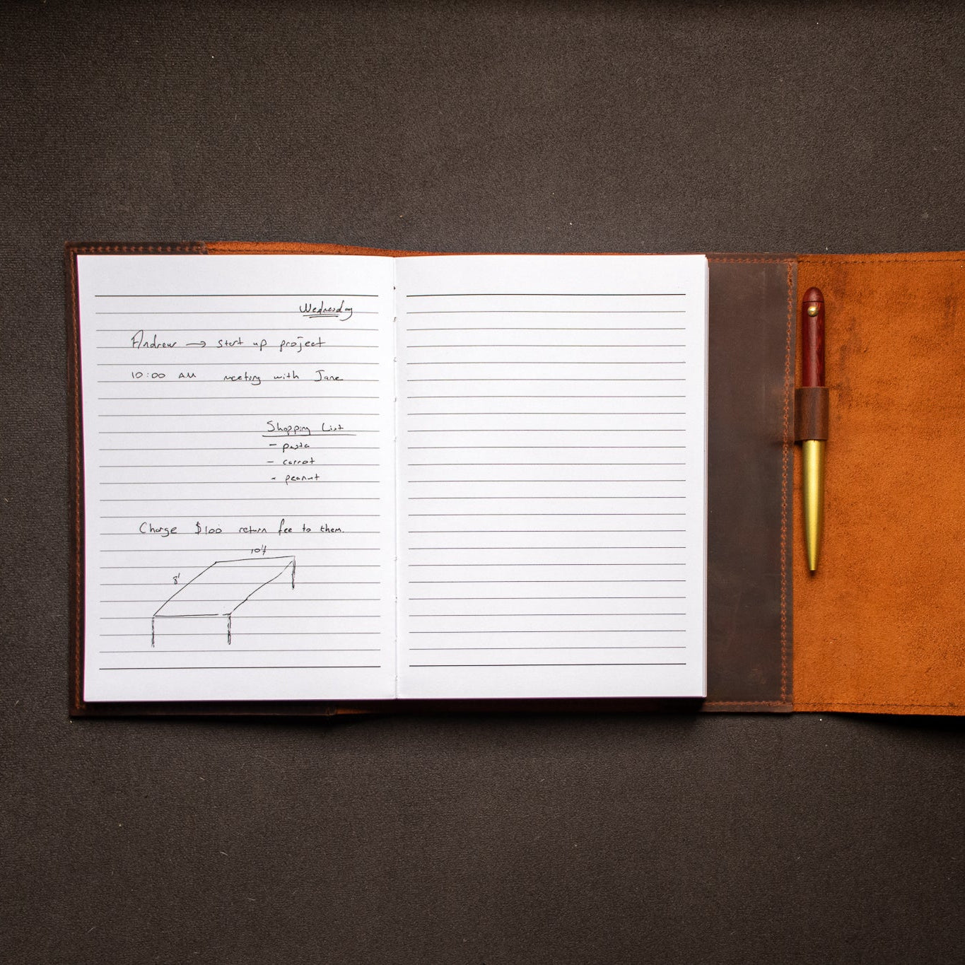 Open notebook with lined pages and a leather cover on a dark surface